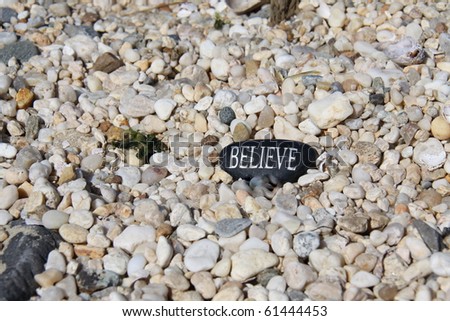 stone with believe written on it among the other rocks
