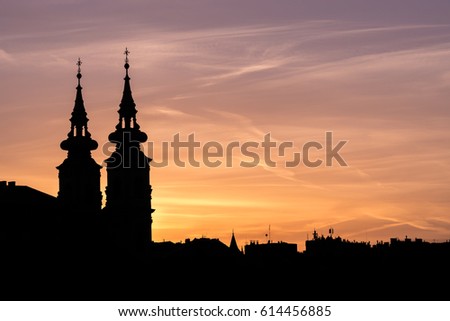 Hues of pink and orange highlight the silhouette of the skyline of Budapest at sunset.
