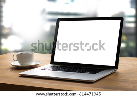 Laptop with blank screen on table interior, man at his workplace using technology