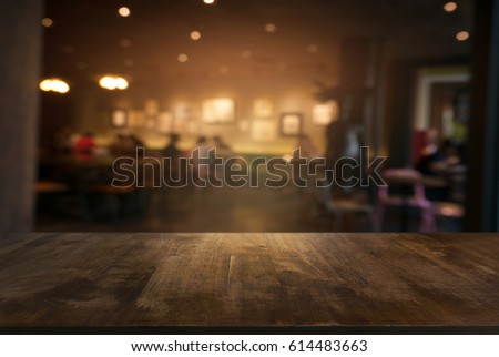 Empty wooden table in front of abstract blurred background of coffee shop . can be used for display or montage your products.Mock up for display of product Royalty-Free Stock Photo #614483663