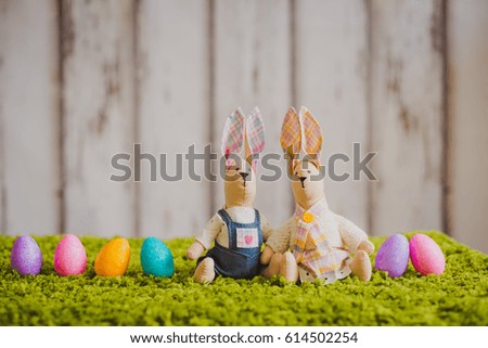 hare sitting on the grass with Easter eggs