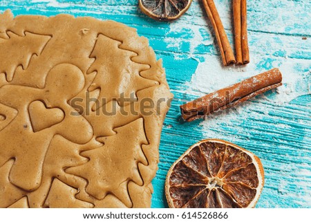 Gingerbread dough with molds for baking cinnamon on blue wooden table.