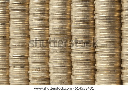 Many and high coins piles arranged next to one another as background.