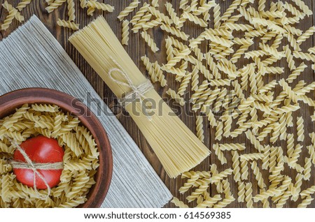 Pasta, tomatoes on wooden background in the plate - vintage effect style pictures