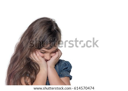 Portrait of ashamed brunette long haired little girl isolated on the white background. The girl is holding her face by both hands.