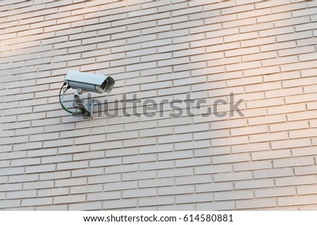 Surveillance camera in brick wall Royalty-Free Stock Photo #614580881