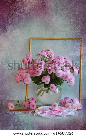 Bouquet of pink chrysanthemums in a glass vase on a colored background