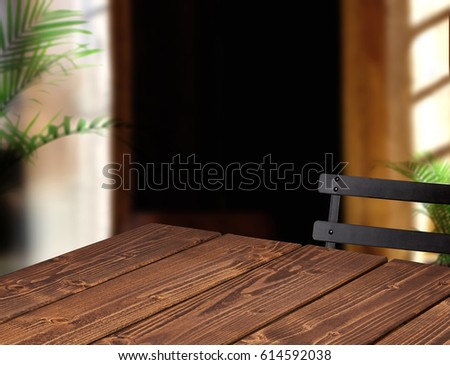 Empty wooden table, chair and plants with sunlight in cafe or restaurant