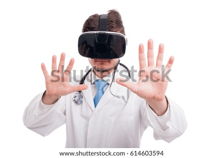 Handsome doctor with vr goggles touching futuristic screen on white studio background