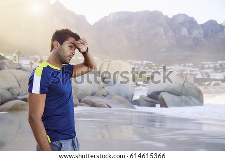 T-shirt guy on beach, wiping brow