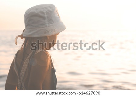 Little Girl Looking At The Sea At Sunset  Royalty-Free Stock Photo #614627090
