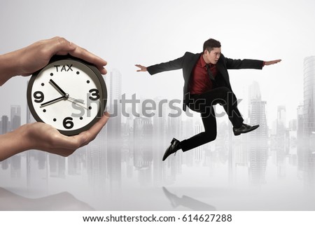 Handsome asian businessman escaping from paying tax on futuristic background