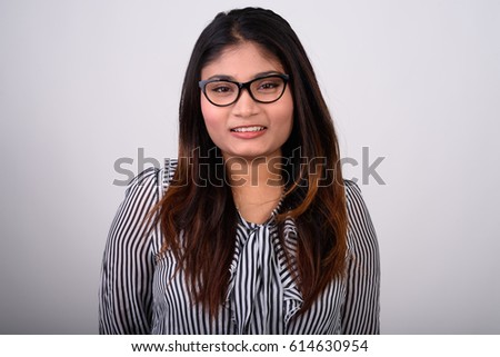 Close up of young happy fat Persian businesswoman smiling while wearing eyeglasses against gray background