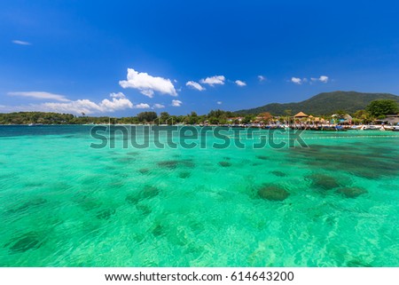 Tropical island beach and clear blue lagoon water with blue sky at Lipe Island, Satun Province, South of Thailand 

