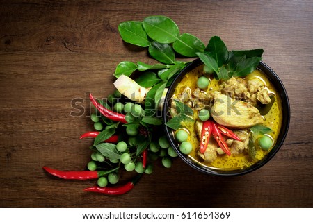 Thai food, green curry chicken with coconut curry on a wooden table. Royalty-Free Stock Photo #614654369