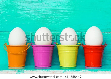 White Easter eggs in colored buckets, selective focus image, Card Happy Easter 