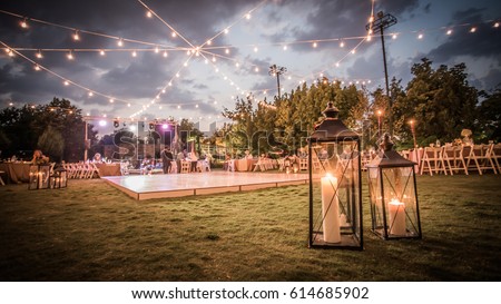Wedding Ceremony with flowers outside in the garden with hanging lights