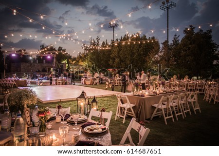 Wedding Ceremony with flowers outside in the garden with hanging lights