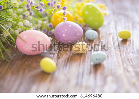 Easter eggs with wildflowers on a brown wooden background. Royalty-Free Stock Photo #614696480