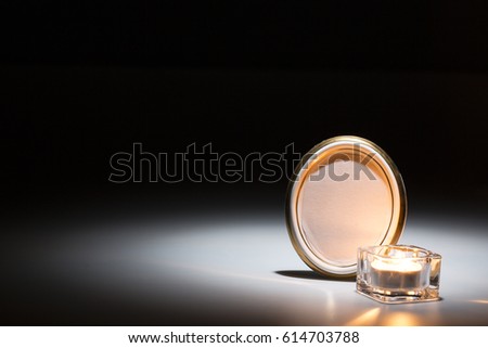 blank mourning frame with glass candle on dark background