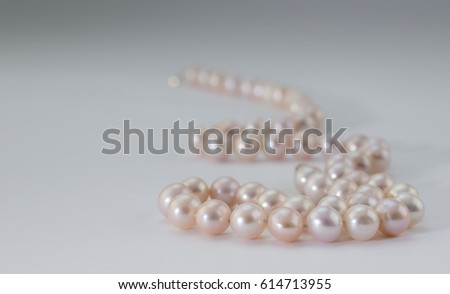 Pink pearl necklace on white background
