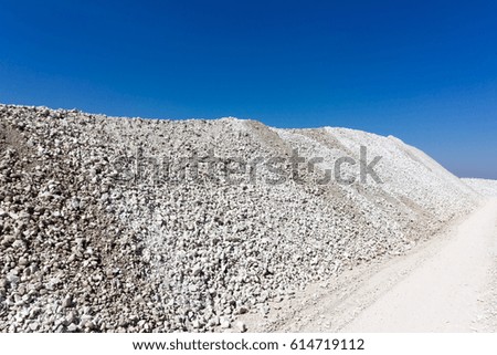 a large mound of crushed stone limestone against the blue sky