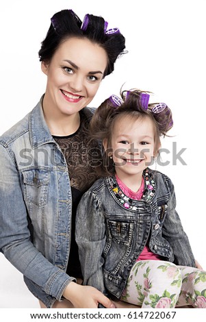 photo of Mother and little daughter in hair curlers