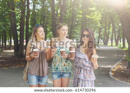Having fun with coffee takeaway. Young girls in summer city making selfie