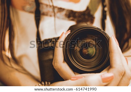 SLR camera lens in girl female hand