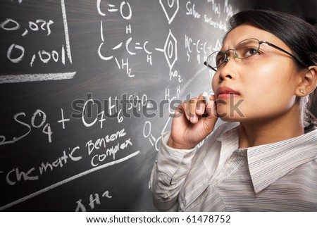 Female student working on difficult equation on blankboard