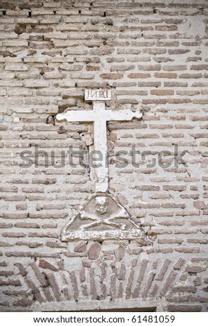 Stone cross on the wall of a church, Spain