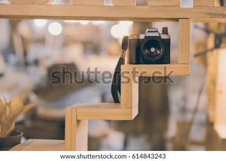 View of vintage toy camera on wooden shelf. Shallow depth of field.