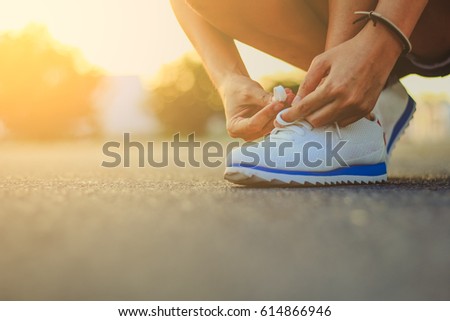 young woman runner tying shoelaces / soft focus picture / Vintage concept