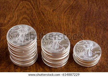 Stacks of American silver dollars on a wood background
