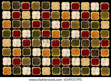Bright spices in square green ceramic bowls on black background contrasting picture