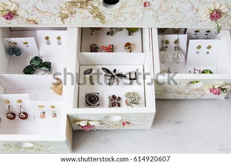 Storage of jewelry in a special chest of drawers, rings and earrings arranged in boxes