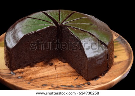 Chocolate cake in wooden dish with coco sauce - black isolated