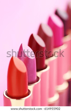 Colorful lipsticks on a pink background