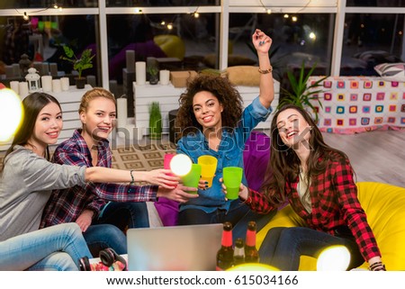 Happy ladies tasting alcohol in room