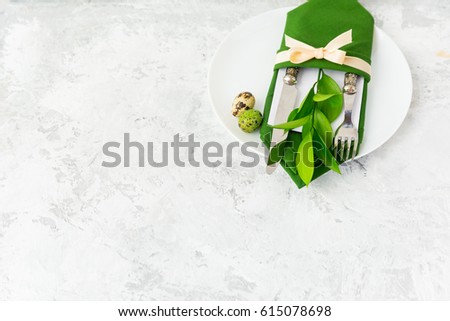 Spring table settings with fresh flower, green napkin and silverware. Holidays background. Copy space 