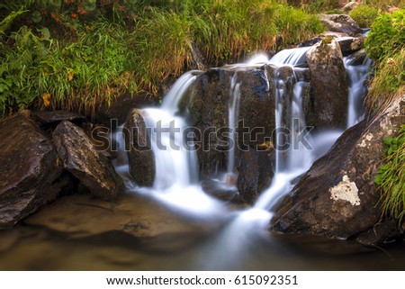 Beautiful waterfall in mountains with white foamy water