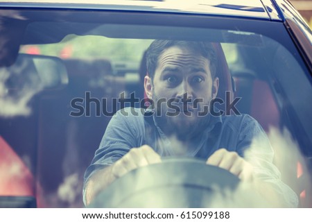 Stressed scared young man driver. Inexperienced anxious motorist concept  Royalty-Free Stock Photo #615099188