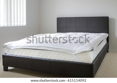 mattress bed topper in a modern bed room from an angle Royalty-Free Stock Photo #615114092