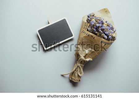 Creative flat lay photo of workspace desk with  black sign , dry flower  on gray wood background