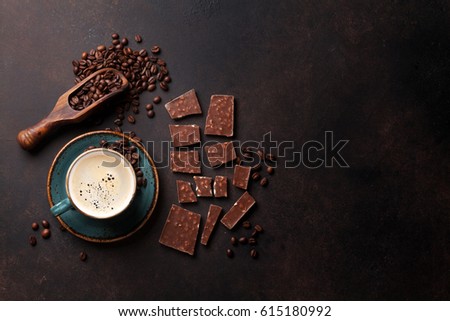 Coffee cup, beans and chocolate on old kitchen table. Top view with copyspace for your text