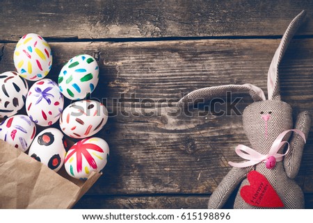Easter bunny on old boards. Old board background. Rabbit. Easter ideas. Easter eggs. Space for text. Image in trendy toning. On the heart text happy Easter.