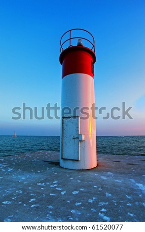 Canadian lighthouse against blue sky with cloud cover