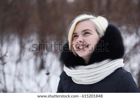 Young beautiful girl on a walk in a winter park
