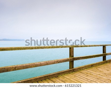 Gradient Color Style  with empty mole. Autumn misty morning on wooden pier above sea. Depression, dark  atmosphere. Touristic mole, wet wooden floor above sea. 