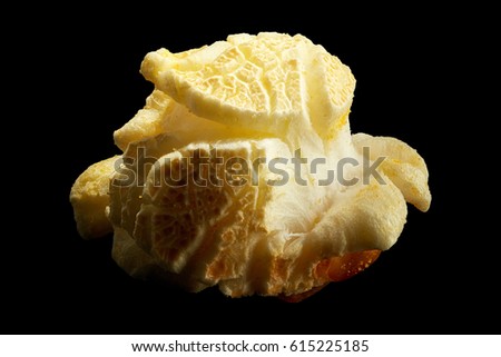 Single popped popcorn isolated on a black background with clipping path. Close-up or macro.